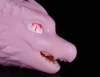 Close-up on the piercing red eye and smooth facial anatomy of dimvra-figurine pink dragon collectible.