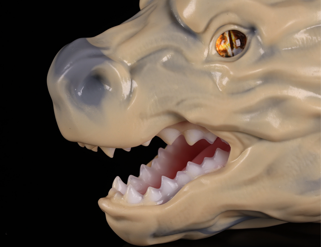 Realistic earth dragon head figurine by dimvra-figurine showing detailed bone-color scales and amber eye.