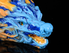 Close-up of realistic eye and vibrant blue and yellow cloud-like mane on dimvra-figurine Oriental dragon figuirne.